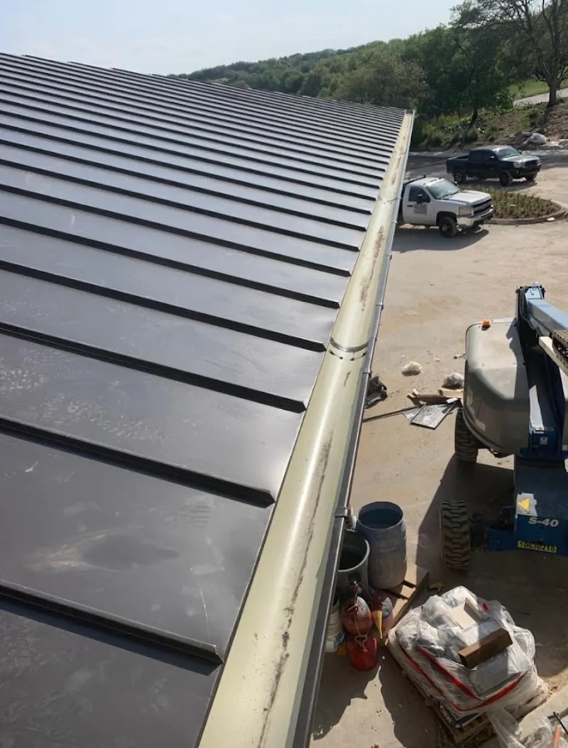 Standing seam panel and gutter detail on a metal roofing jobsite in Fort Stewart